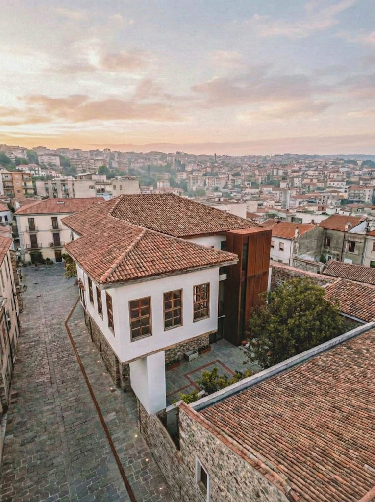 Yapının kuş bakışı görünümü; kiremit çatılar, avlu ve Burdur kent silueti